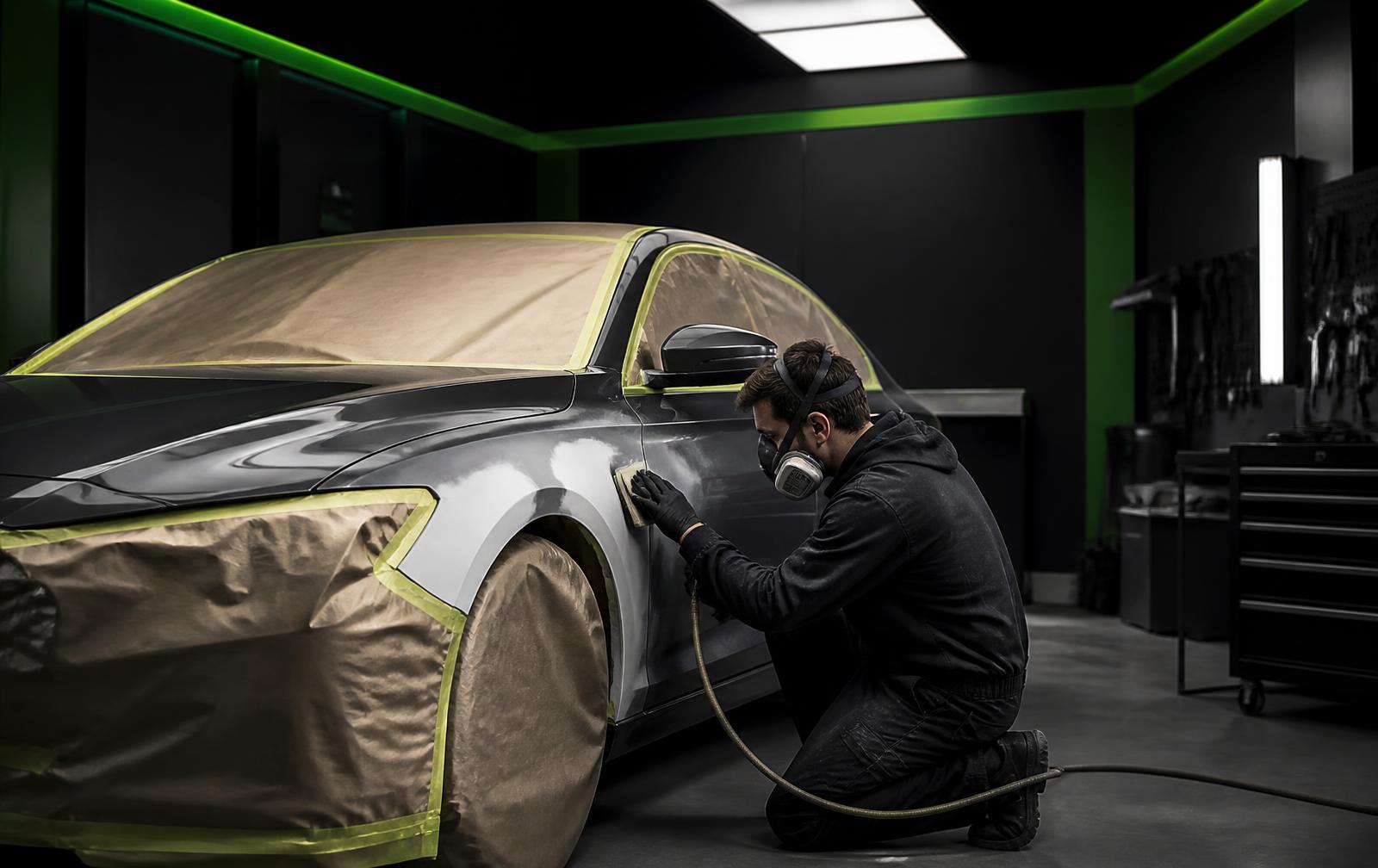 Body technician prepping a panel for refinishing