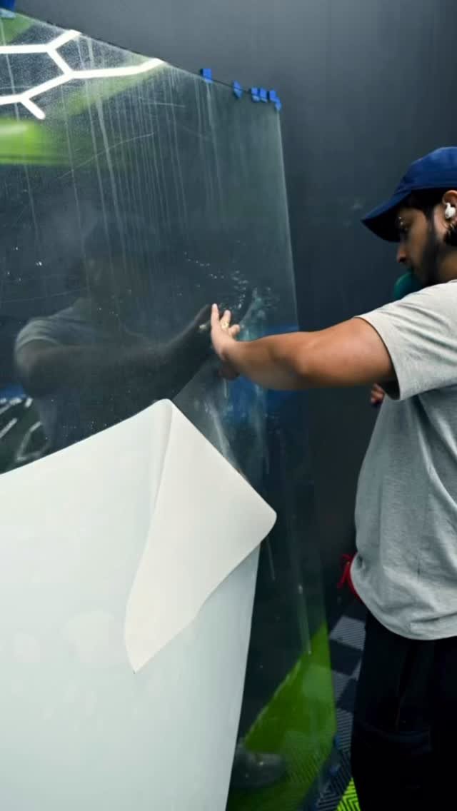 Installer working window film in the NTX Motorworks install bay